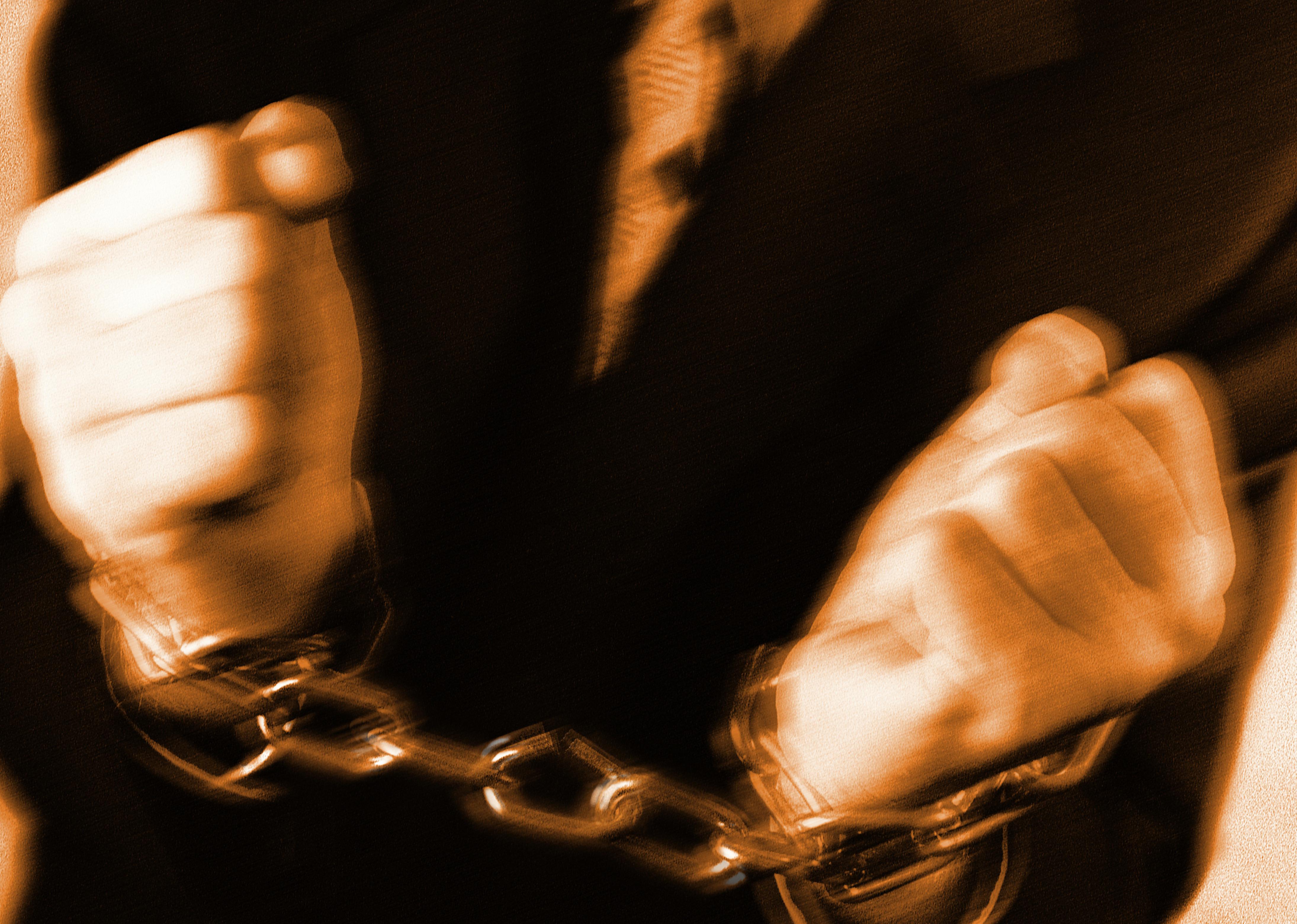 Businessman with chain around hands (blurred motion, toned B&W)