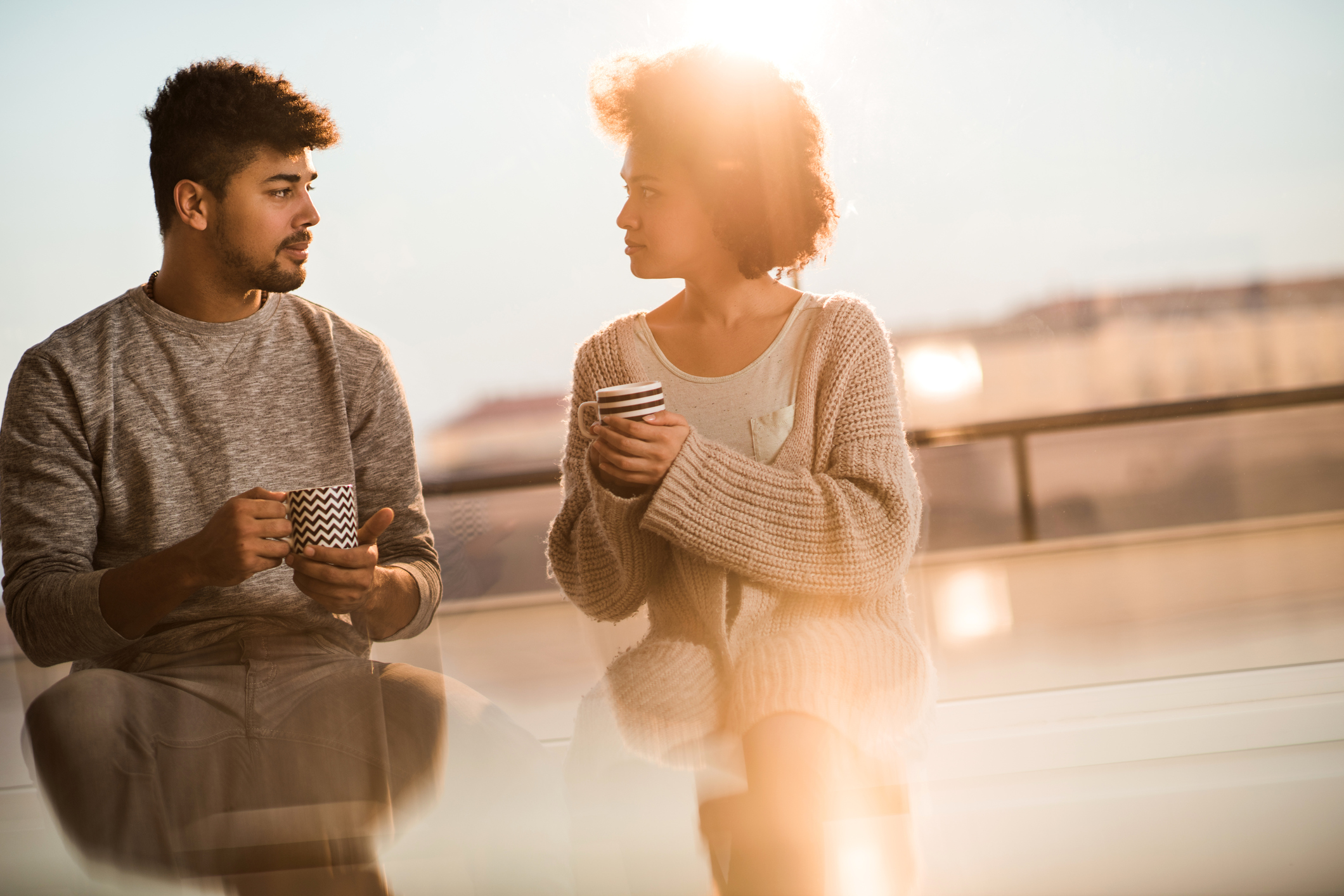 Young black couple talking to each other during coffee time.