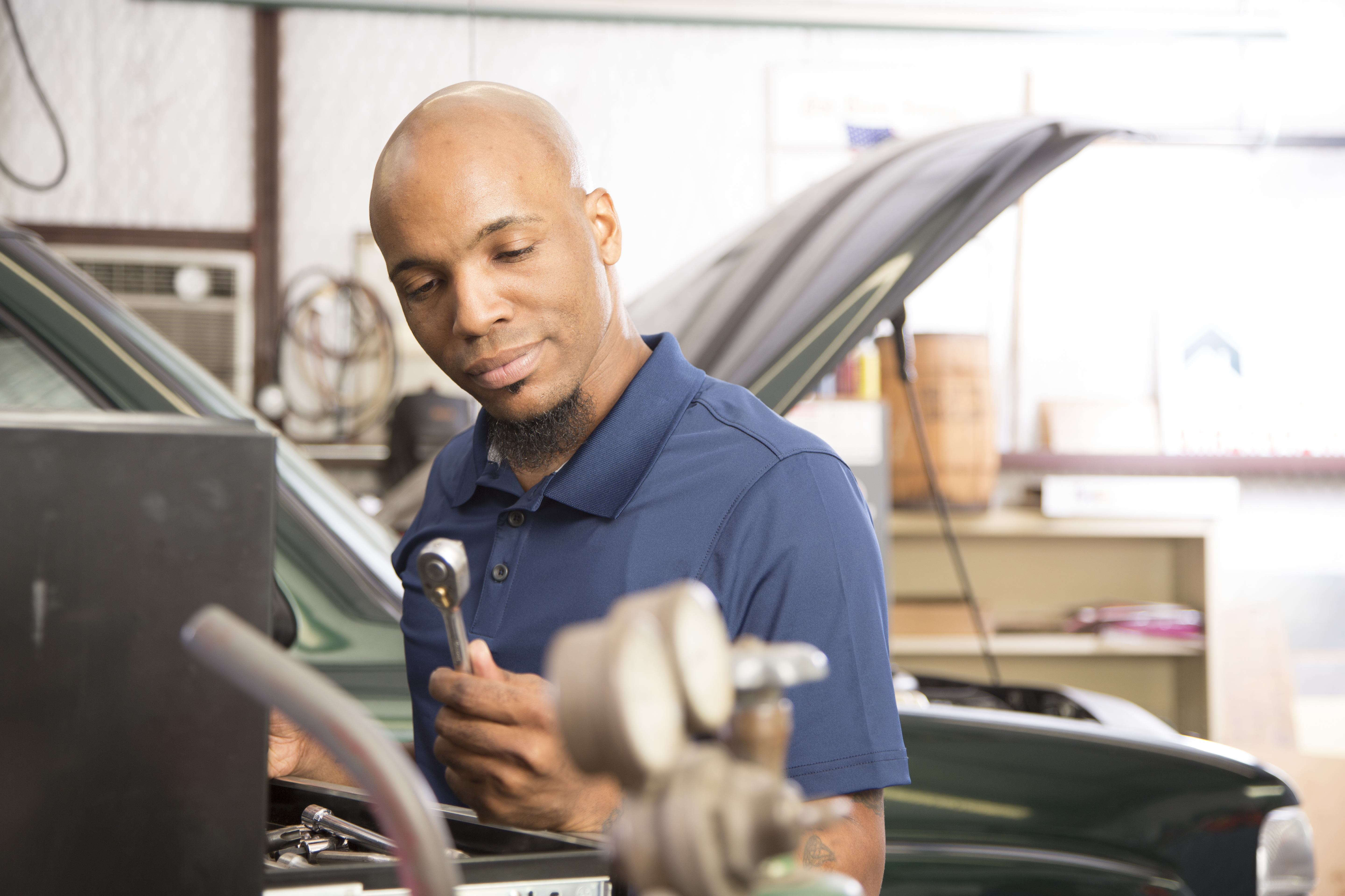 African descent mechanic working in auto repair shop.