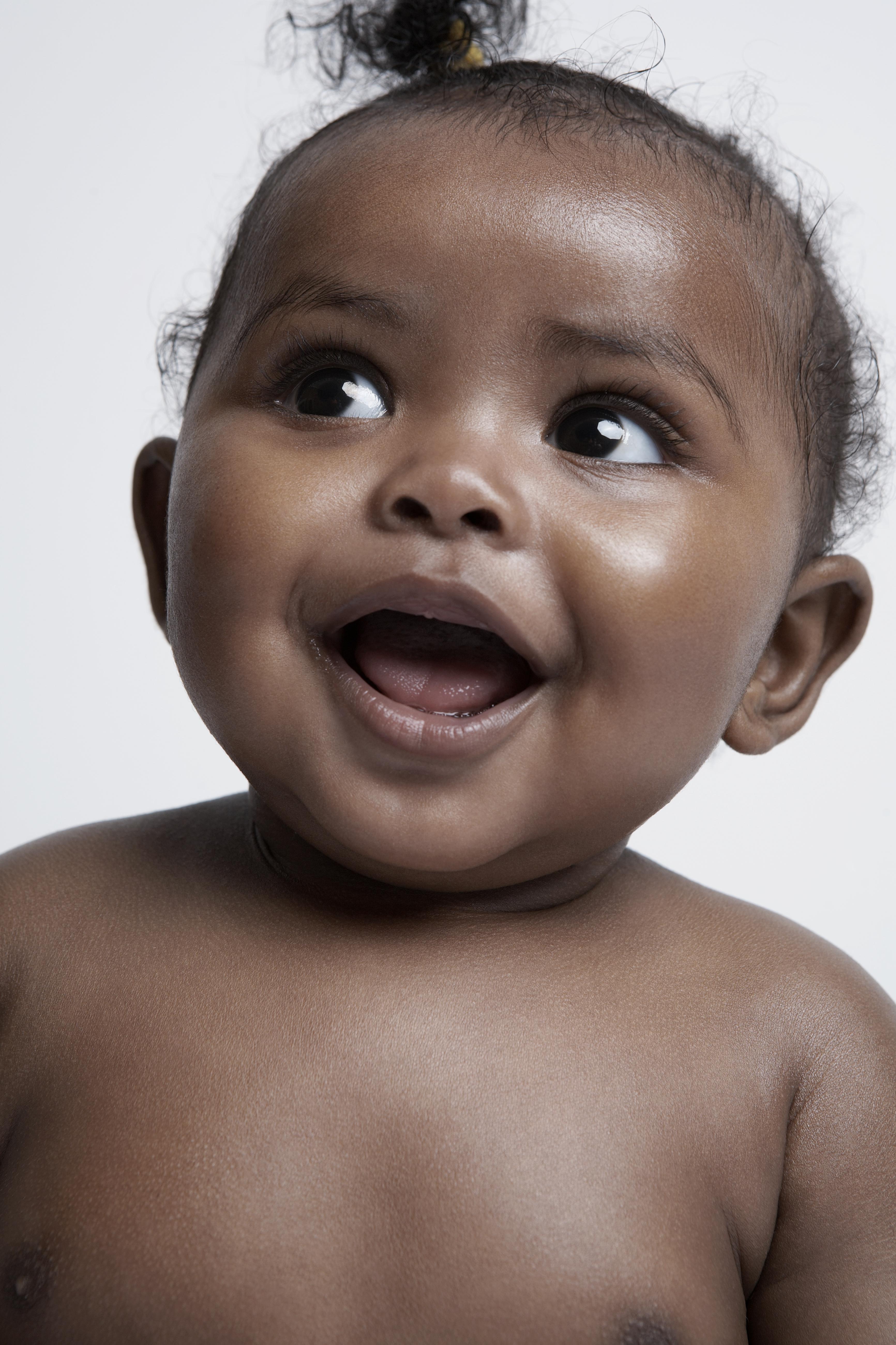 Baby girl (6-9 months) looking up, portrait