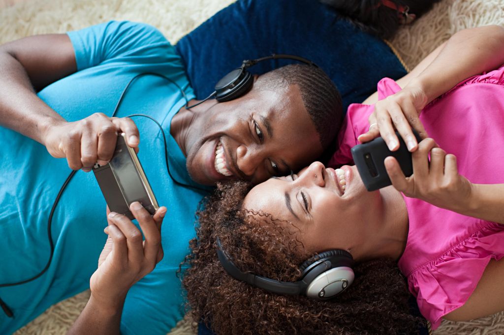 Man and woman playing on handheld device and smartphone